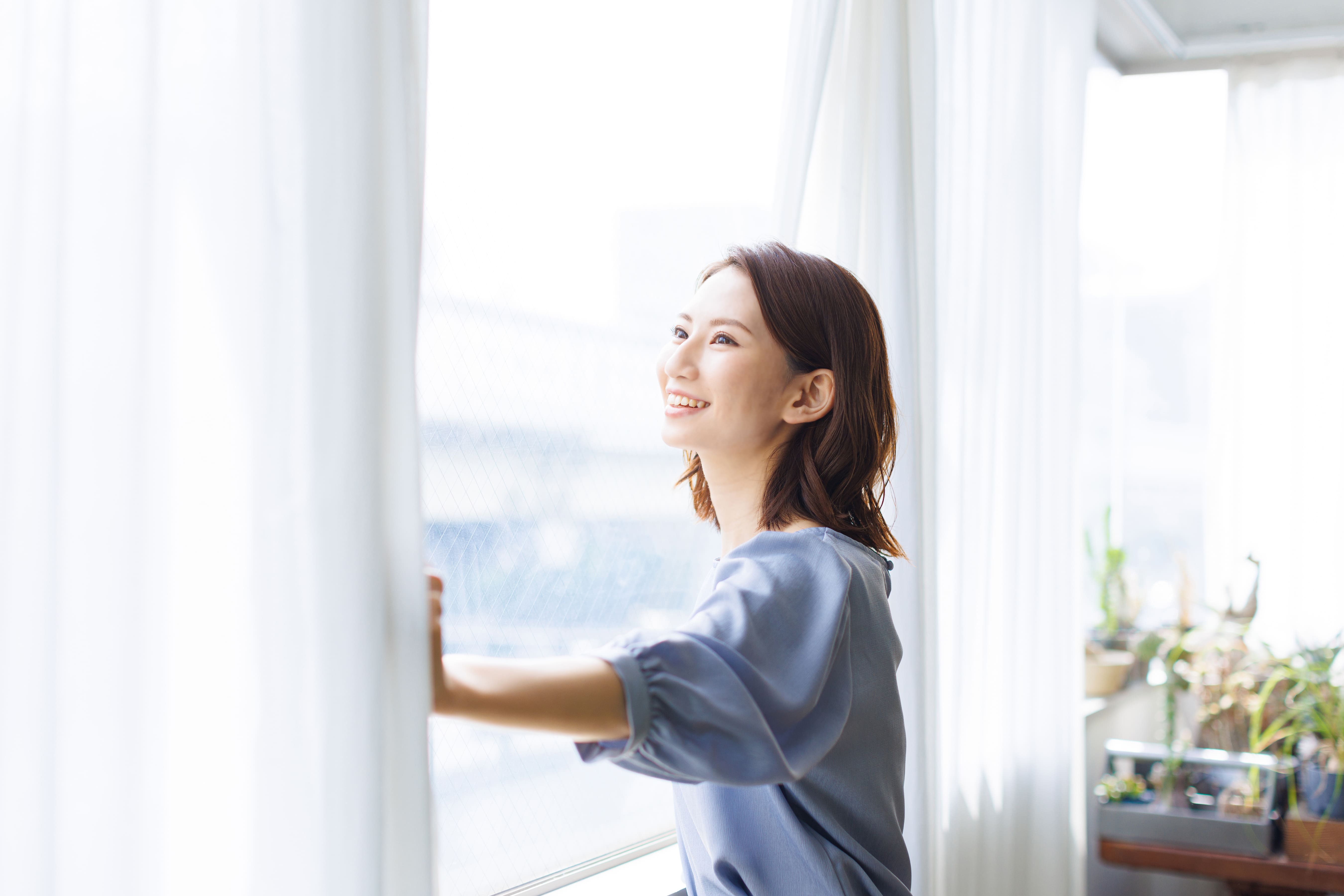 女性が窓をみて笑っている